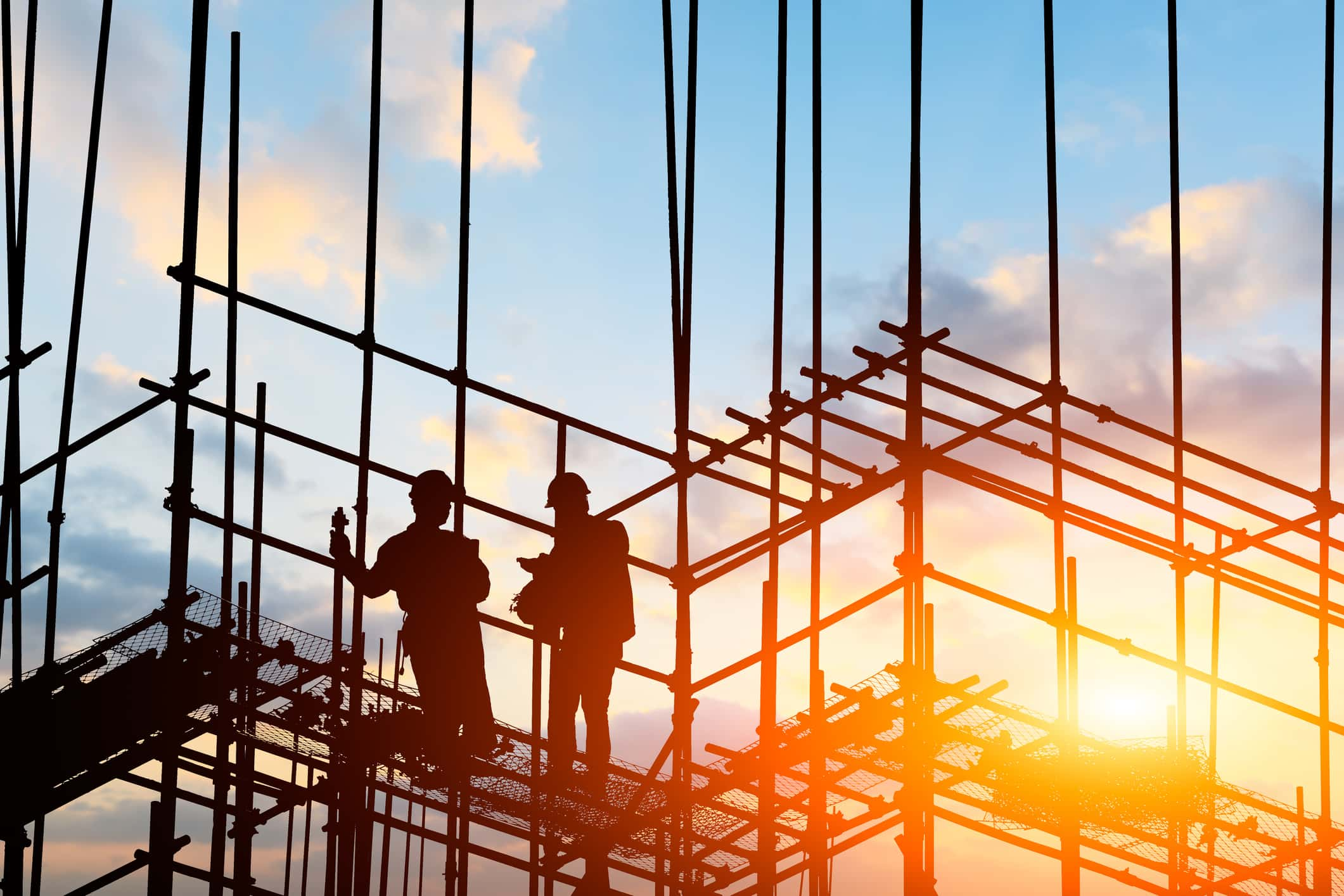 Construction workers standing on scaffolding on building worksite