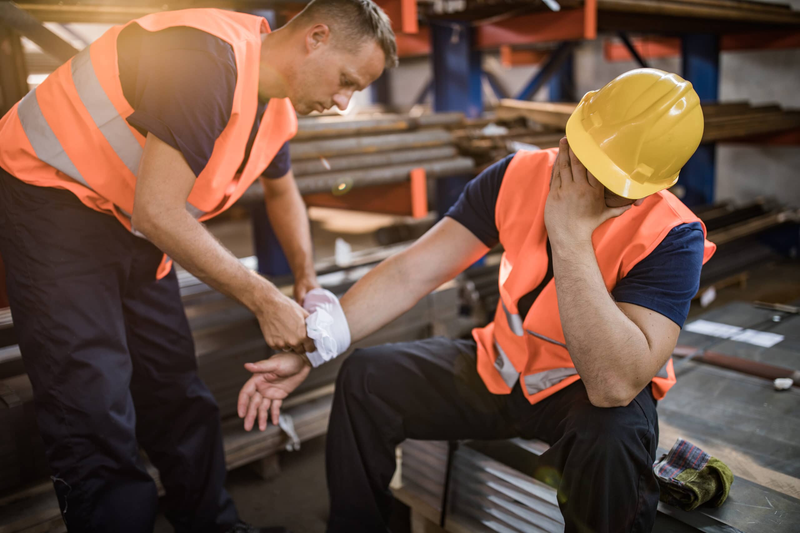 Tradie is wrapping the injured arm of another tradie