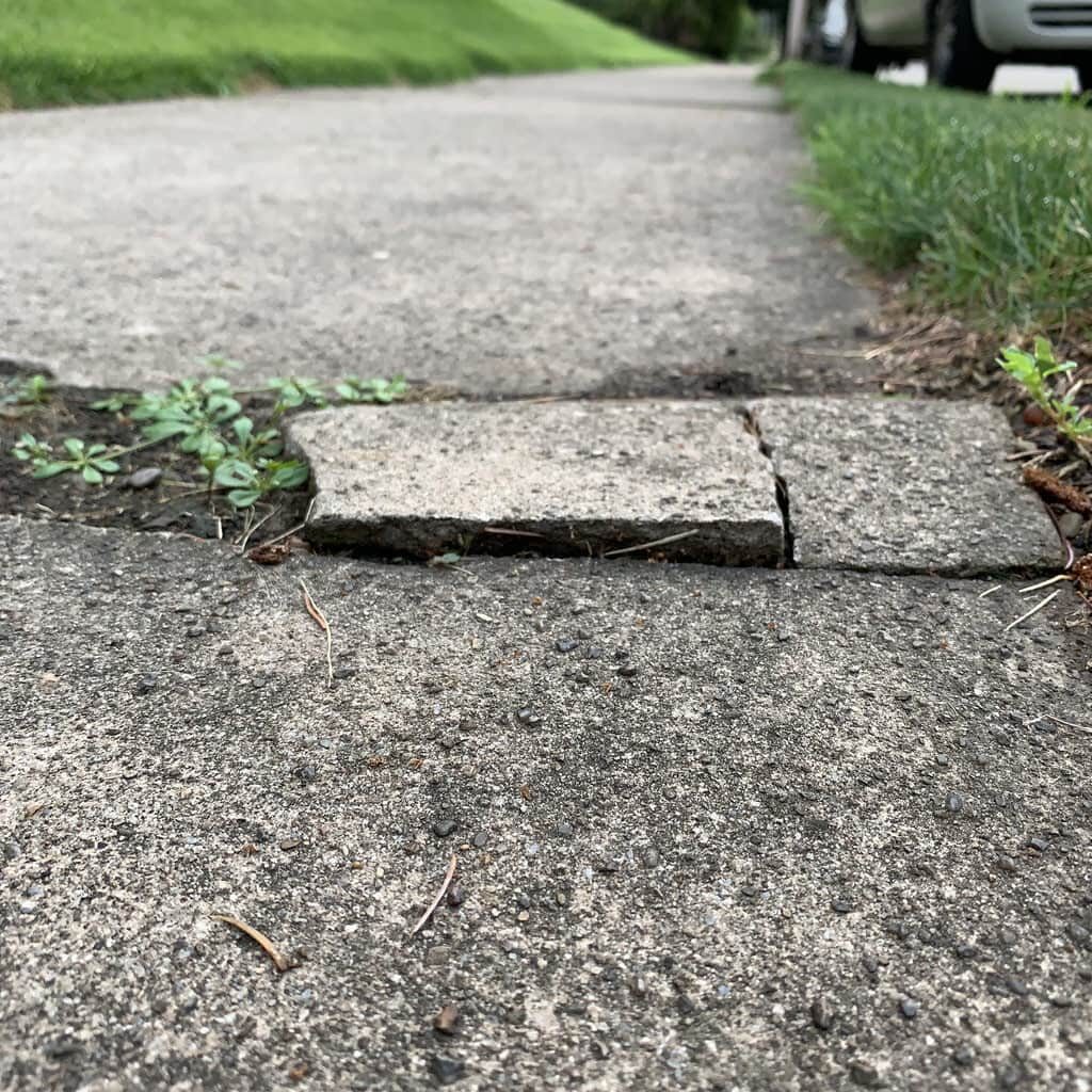 Broken cracked pavement on public sidewalk