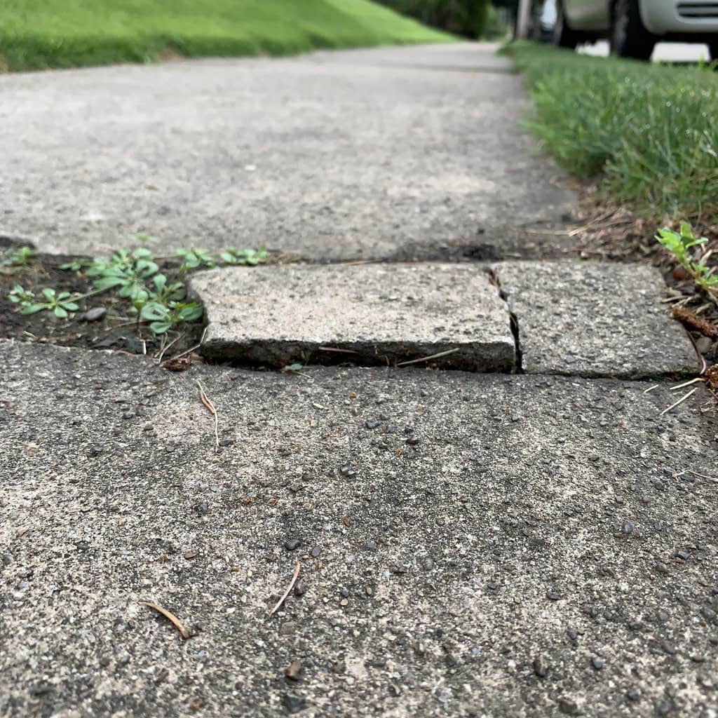 Broken cracked pavement on public sidewalk