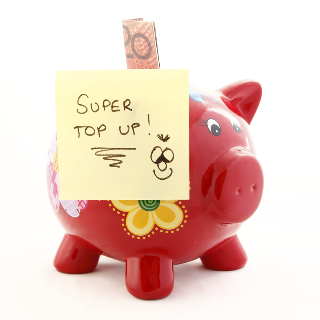 Red piggy bank with a post it note saying "super top up" and a twenty dollar bill sticking out from the top