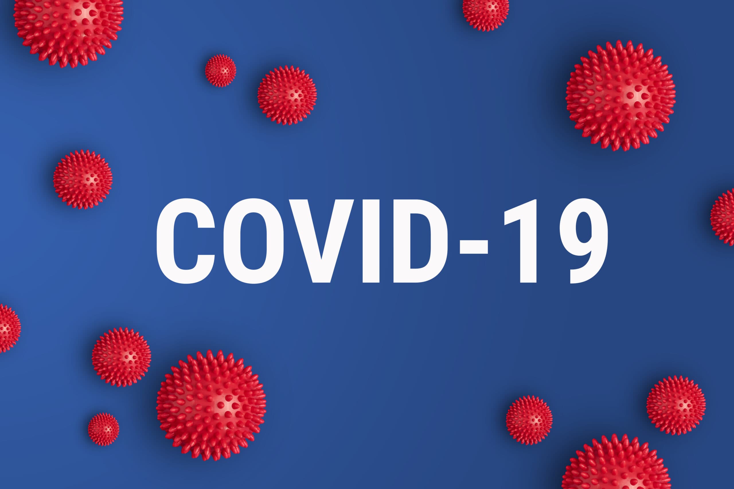 Blue background with huge text saying "COVID-19" and red virus icons surrounding it