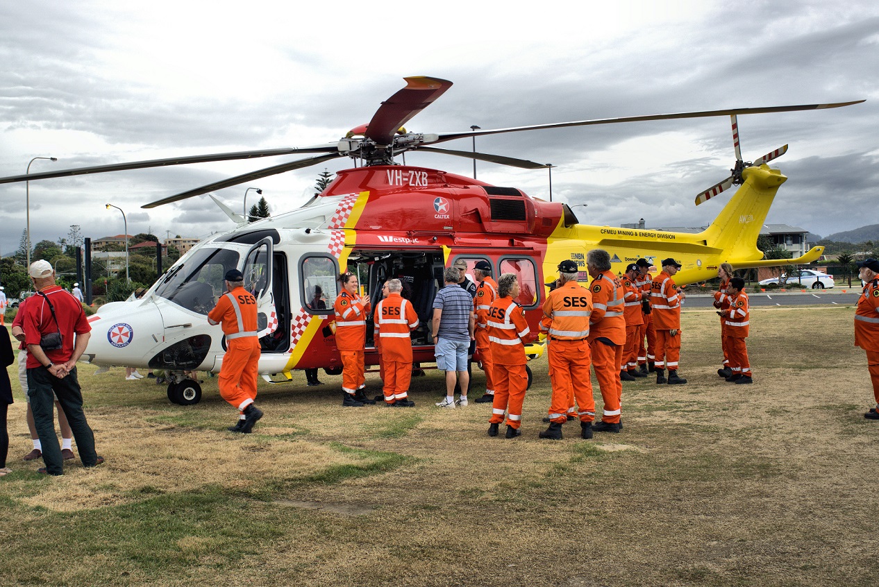 Volunteers of State Emergency Service or SES Australia standing in front of helicopter