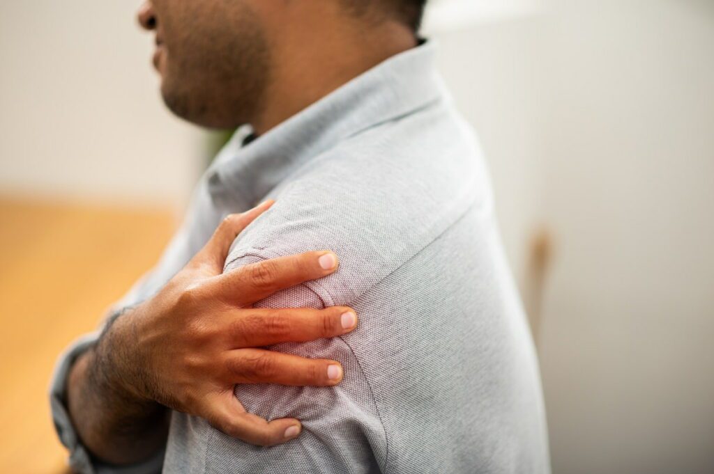 A man with chronic shoulder pain after lifting heavy items at work
