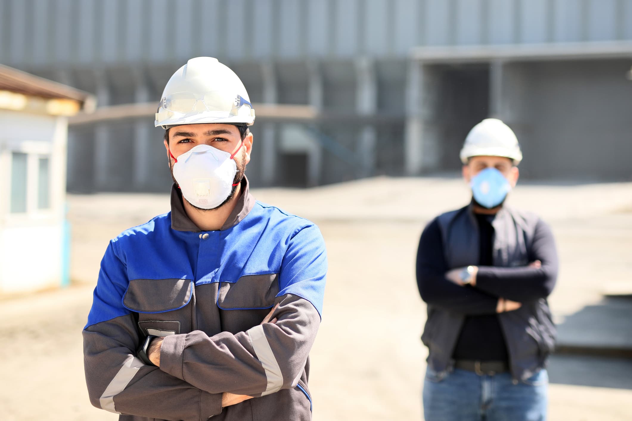 Young tradesmen standing front on wearing protective masks to prevent from occupational disease