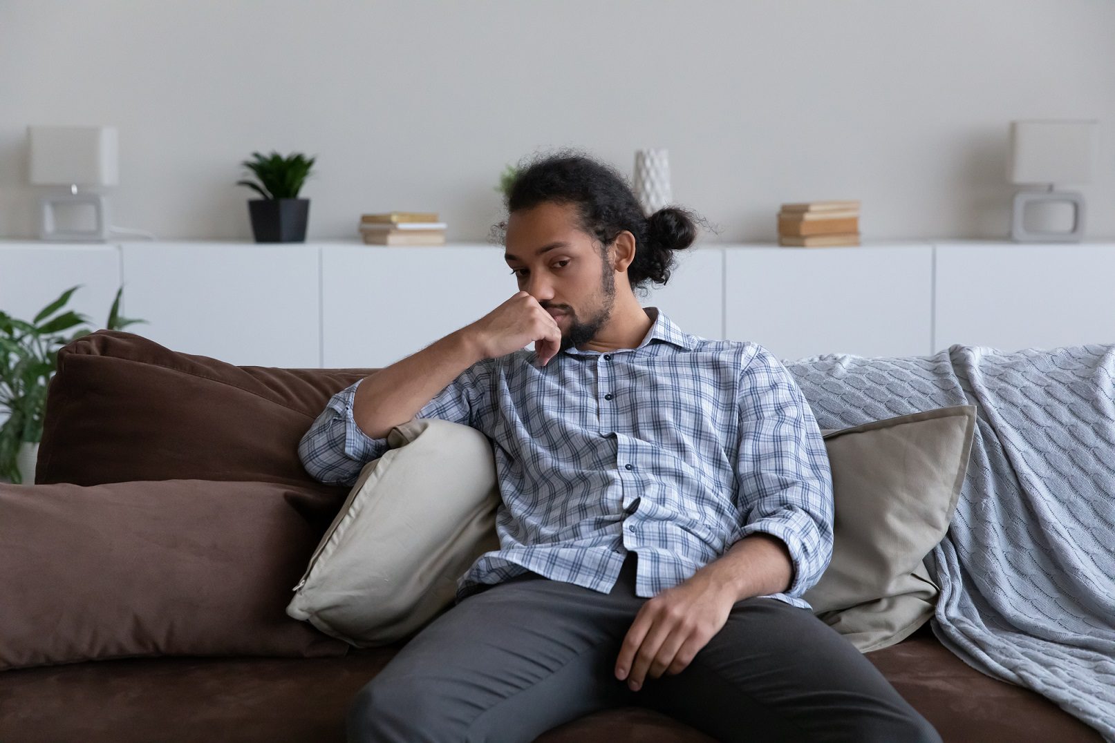 Man sitting on sofa thinking about making a TPD claim for his chronic illness