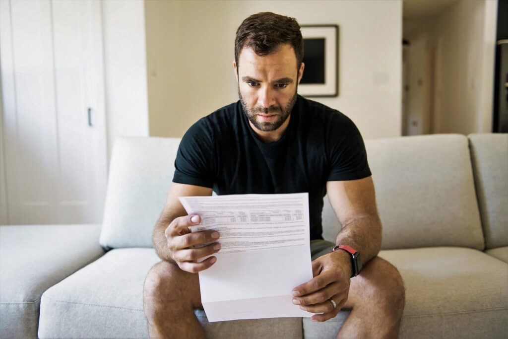 Man starting at debt repayment letter because of not declaring income correctly